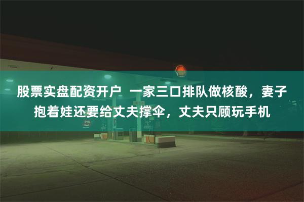 股票实盘配资开户  一家三口排队做核酸，妻子抱着娃还要给丈夫撑伞，丈夫只顾玩手机